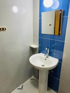een badkamer met een witte wastafel en een spiegel bij Semiramis Hotel Royal Palace in Marsa Matruh