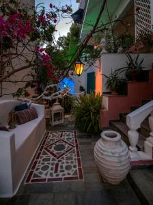 a courtyard with a vase and stairs with flowers at Stella Studios in Poros