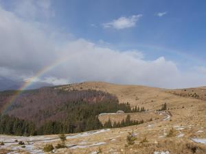 un arco iris sobre una montaña con un camino en Alena, en Ranca