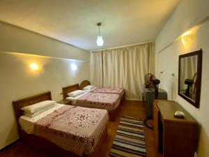 a hotel room with two beds and a television at Semiramis Hotel Royal Palace in Marsa Matruh