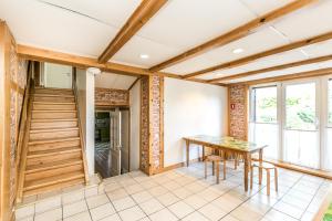 a dining room with a table and a staircase at Sea Rooms ENGURE in Engure
