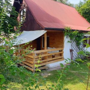 una piccola cabina in legno con tetto rosso di Domek letniskowy Jezioro Białe a Okuninka