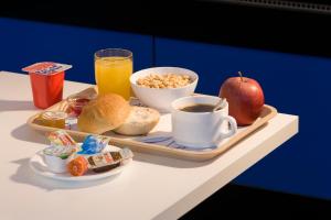 
a table topped with a tray of food and a cup of coffee at ibis budget Ulm City in Ulm
