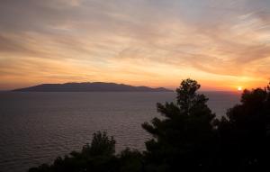 a sunset over a large body of water at Boutique Hotel Torre Di Cala Piccola in Porto Santo Stefano