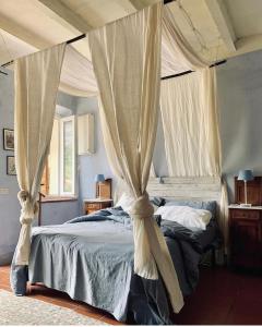 - une chambre avec un lit à baldaquin et des rideaux dans l'établissement Relais B&B Betty Bike, à Sasso Feltrio