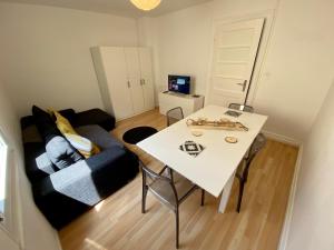 a living room with a white table and a couch at Le 16 - Charmant appartement proche du centre ville in Strasbourg