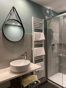 uma casa de banho com um espelho, um lavatório e um chuveiro em Delta Park em Porto Viro
