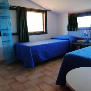 a room with two beds and a window at Villa Kampia in Capo Vaticano