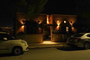 twee auto's geparkeerd voor een huis 's nachts bij Locanda Degli Scrittori in Agrigento