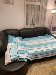 - un canapé avec une couverture dans le salon dans l'établissement Dani Apartment, à Rijeka