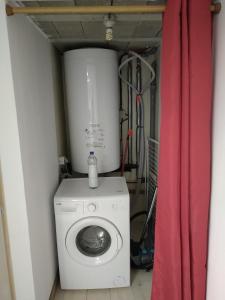 a laundry room with a washing machine and a red curtain at Belle vue au coeur de la verdure in Aisey-sur-Seine