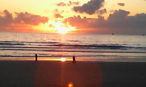 two people walking on the beach at sunset at Vacances à la plage Cabourg F2 in Cabourg