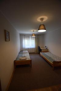 Pokój z 2 łóżkami, krzesłem i oknem w obiekcie Mieszkanie Gdynia Fikakowo w mieście Gdynia