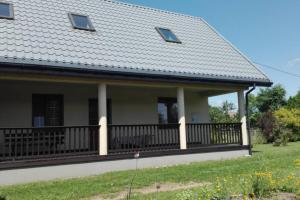 een huis met een balkon met een dak bij Dom w spokojnej okolicy in Dubicze Cerkiewne