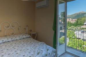 ein Schlafzimmer mit einem Bett und einem Balkon in der Unterkunft Mandevilla Home in Caiazzo
