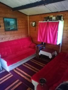 a red couch in a room with a red curtain at Zlatar Lake - cottage in Kokin Brod