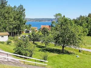 a view of a field with trees and a lake at 6 person holiday home in BRASTAD in Brastad +15 photos