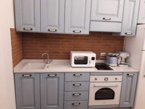 a kitchen with white cabinets and a sink and a microwave at Via d'acqua Al Mulino -City Center- BO in Bologna +21 photos