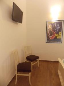 a living room with two chairs and a flat screen tv at Via d'acqua Al Mulino -City Center- BO in Bologna