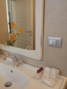 a bathroom with a sink with a mirror and a sink at Via d'acqua Al Mulino -City Center- BO in Bologna