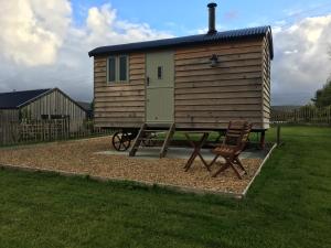 a small cabin with a chair in front of it at 40 Bernisdale - Shepherds Hut in Skeabost