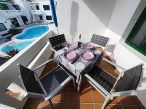 a table with pink plates on it on a balcony at Princesa 202 in Puerto del Carmen