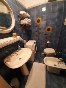 W łazience znajduje się umywalka, toaleta i lustro. w obiekcie Bethel House w mieście Gardone Riviera