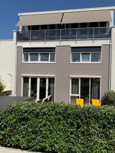 un edificio con sillas amarillas delante de él en Zilvermeeuw - Drieplassenweg, en Katwijk