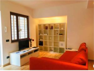 ein Wohnzimmer mit einem roten Sofa und einem TV in der Unterkunft Casetta Nica in Torvaianica