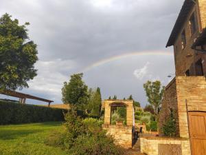 Ein Regenbogen am Himmel über einem Hof in der Unterkunft Agriturismo San Pierino in Monteroni dʼArbia