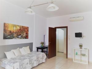a bedroom with a bed and a painting on the wall at Portantica in Conversano