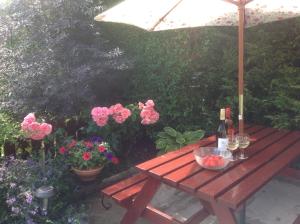 una mesa de picnic de madera con dos copas de vino y flores en The Garden Flat, en Crieff