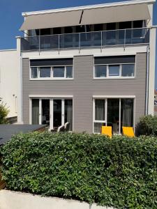 un edificio con sillas amarillas delante de él en Zilvermeeuw - Drieplassenweg, en Katwijk
