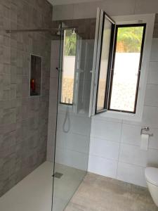 baño con ducha, aseo y ventana en Villa Altea Lomalisa, en Altea