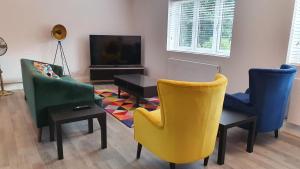 a living room with three chairs and a tv at Garland Modern Spacious Apartment, Brentwood 2 in Brentwood