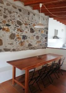 a wooden table in a room with a stone wall at Casas Rurales Hermigua in Hermigua