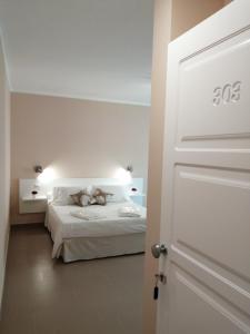 1 dormitorio con cama y puerta blanca en Villa Laura Residence Hotel Apartments & Studios, en Ascea
