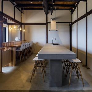 a kitchen with a large table and stools at kotobukian 寿庵 in Awaji