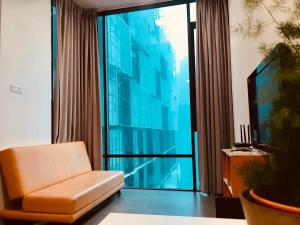 ein Wohnzimmer mit einem Stuhl und einem großen Fenster in der Unterkunft Montana Suite 5, Empire Damansara in Petaling Jaya