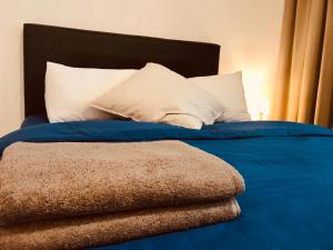 Bett mit blauer Bettwäsche und weißen Kissen in der Unterkunft Montana Suite 5, Empire Damansara in Petaling Jaya