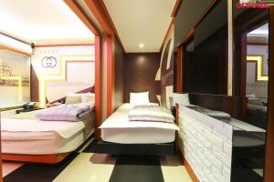 pokój z dwoma łóżkami i telewizorem w obiekcie Jinju GnG Motel w mieście Jinju