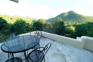 a table and chairs on a balcony with mountains at Hi-scene Resort in Suan Phung