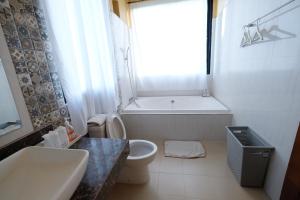 y baño con bañera, aseo y lavamanos. en Hi-scene Resort, en Suan Phueng