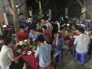 een groep mensen die aan tafel eten bij Nhà nghĩ Gia An in Lai Sơn