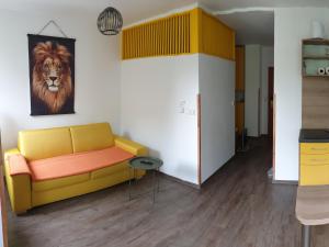 フリンブルクにあるApartman pohoda Lipno1のリビングルーム(黄色いソファ、獅子絵付)