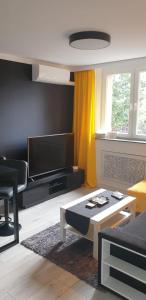 ein Wohnzimmer mit einem TV und einem Tisch in der Unterkunft No71 The Luxury Apartment in Głogów