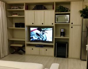 een woonkamer met een tv in een entertainmentcentrum bij Moema Times Square SP Wi-Fi 5G Home Office Kitchen 50" TV Free Parking & Free Laundry in Sao Paulo
