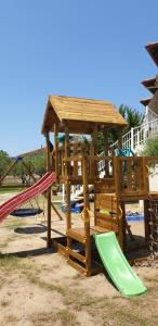 une aire de jeux en bois avec un toboggan et un kiosque dans l'établissement Villa Irida, à Sarti