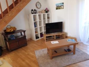ein Wohnzimmer mit einem TV und einem Couchtisch in der Unterkunft chez clion in Lorigné