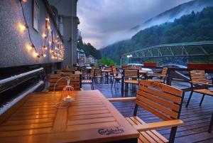 un restaurante con mesas de madera y sillas en el balcón en Vila Teleconstructia, en Slănic-Moldova